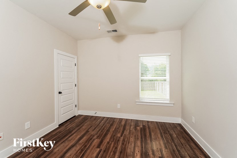 the living room of a home with wood flooring and a ceiling fan