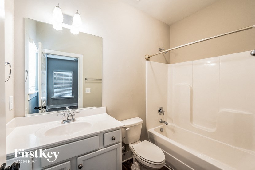 a bathroom with a sink toilet and tub and a mirror