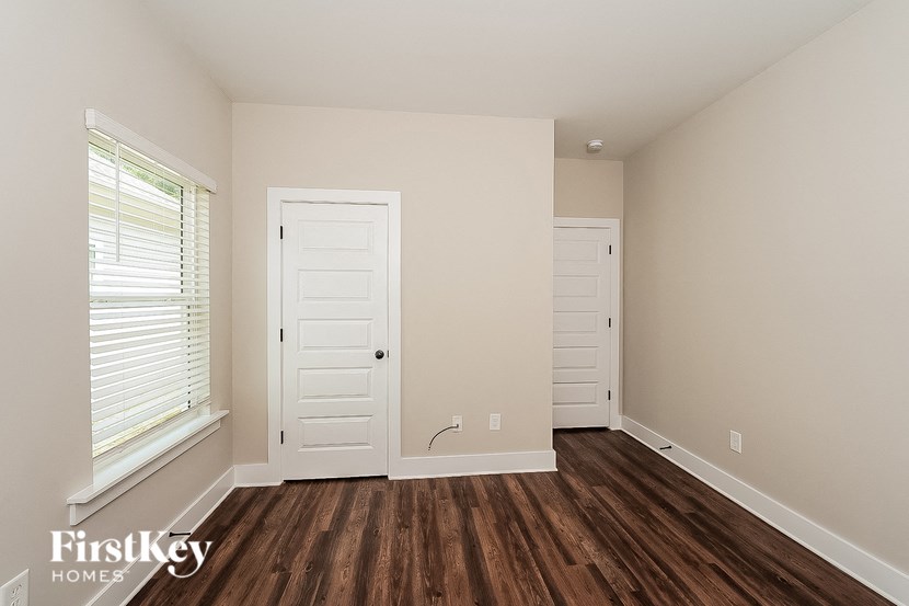 the living room of a home with wooden floors and a white door