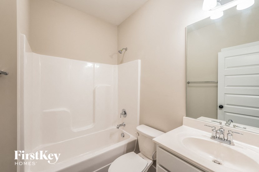 a white bathroom with a tub and a sink and a toilet