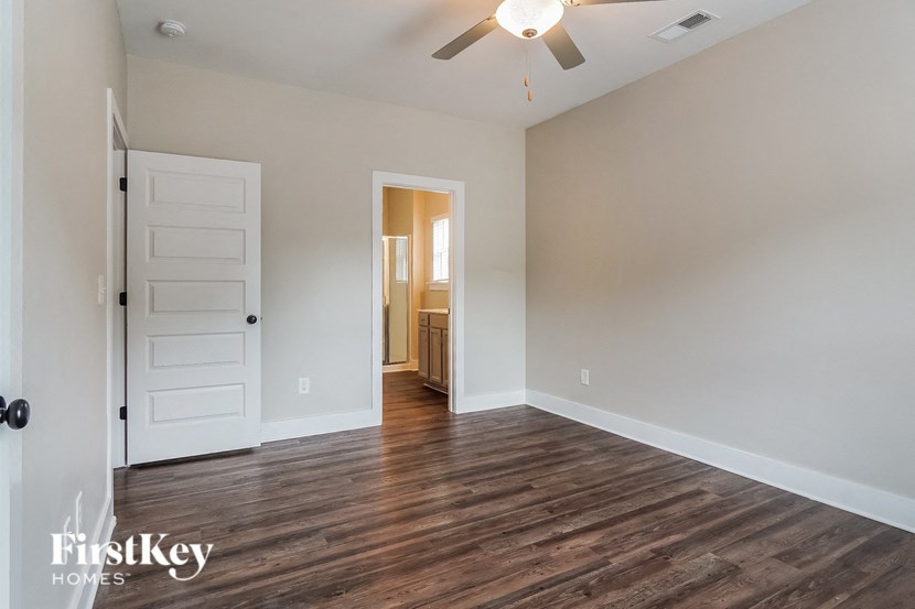 a living room with a white door and a ceiling fan