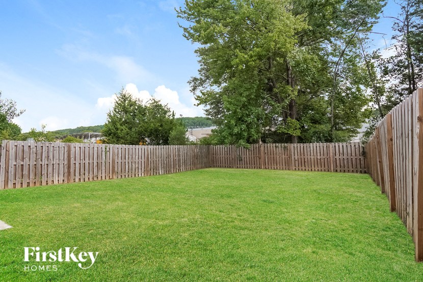 a backyard with a wooden fence and green grass