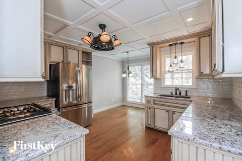 A kitchen with a stove top oven and a refrigerator.