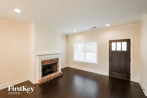 a living room with a fireplace and a dark wood floor