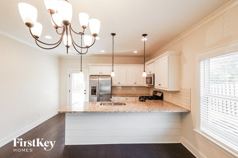 a kitchen with white cabinets and a granite counter top