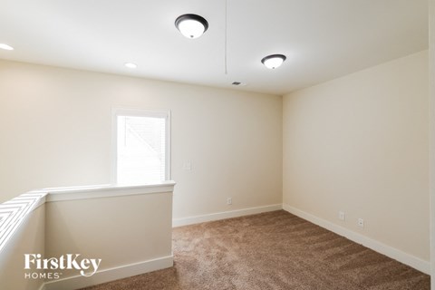 a bedroom with white walls and carpet and a window