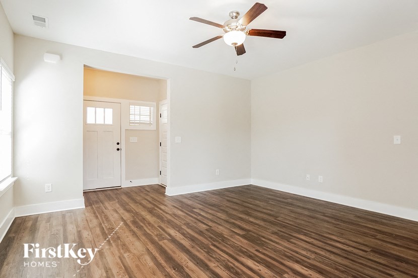 a living room with hardwood floors and a ceiling fan