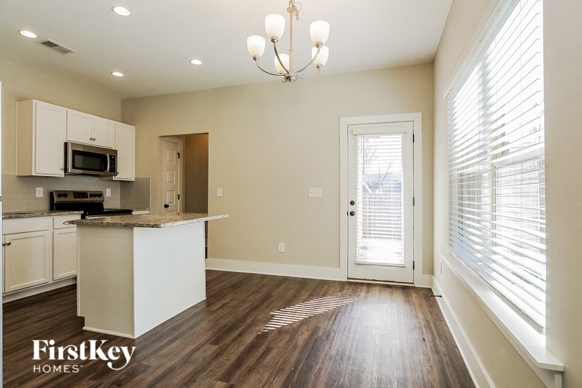 an empty kitchen with a door to the living room