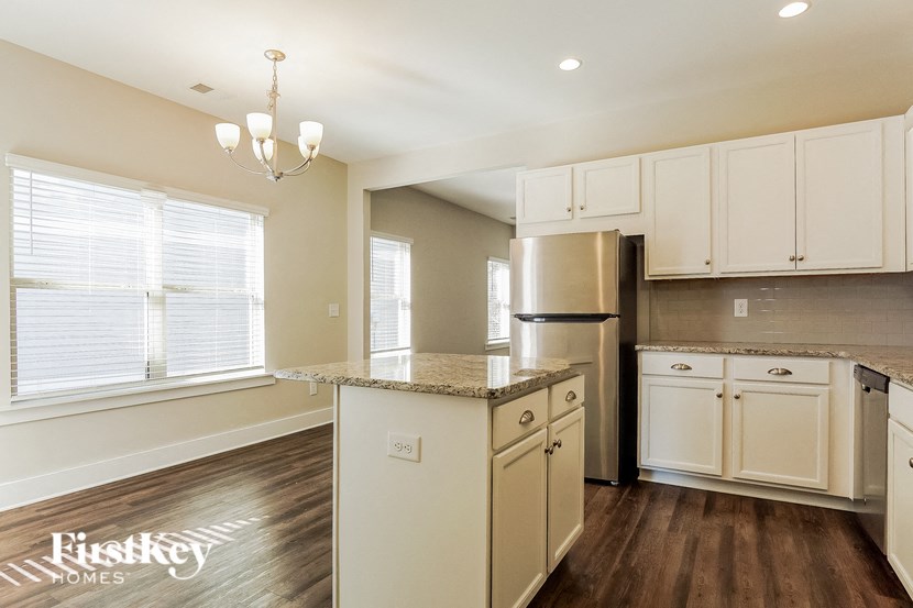 a kitchen with white cabinets and stainless steel appliances and a granite counter top