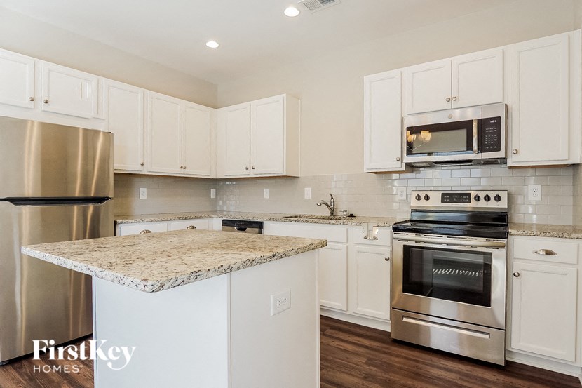 a kitchen with white cabinets and stainless steel appliances