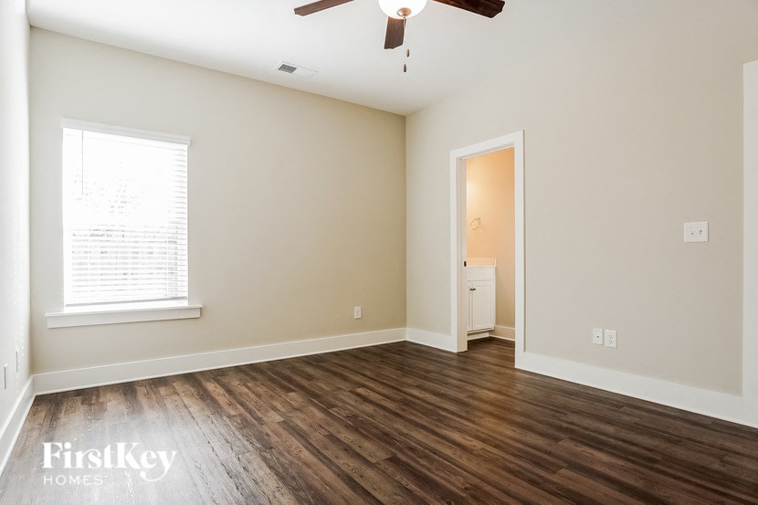 a living room with wood floors and a ceiling fan