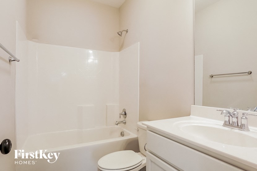a white bathroom with a sink toilet and bath tub