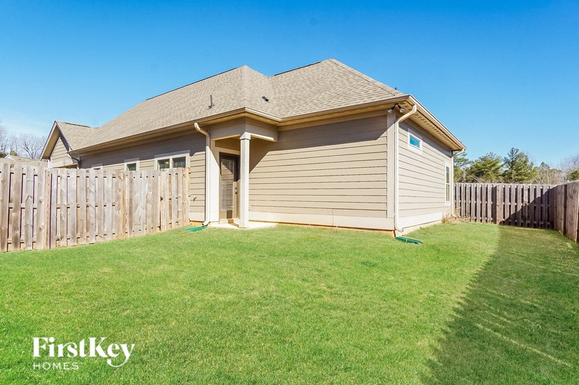 the backyard of a house with a yard and a fence