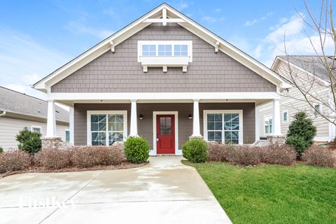 a home with a red door and a porch