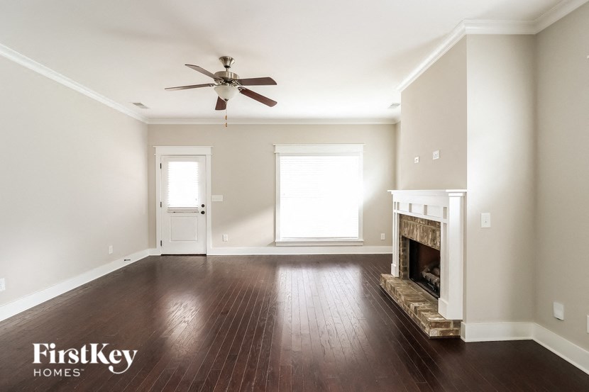 a empty living room with a ceiling fan and a fireplace