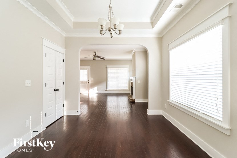 a hallway with wood floors and a large window and a chandelier