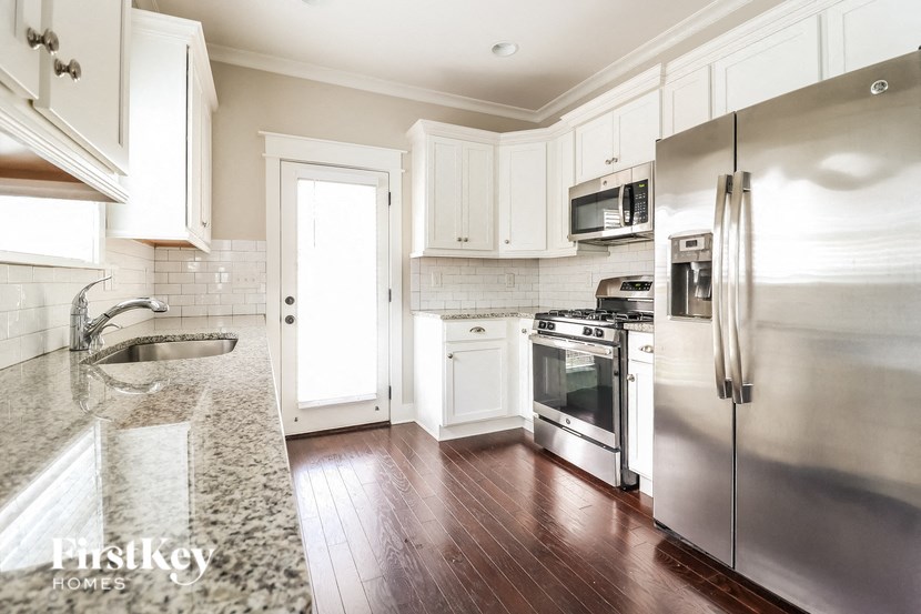 a kitchen with stainless steel appliances and white cabinets