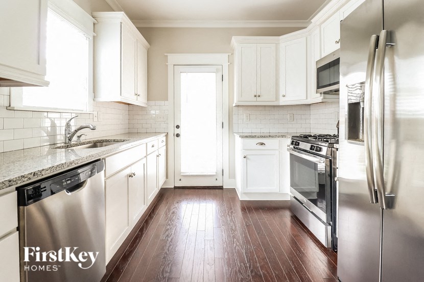 a kitchen with white cabinets and stainless steel appliances