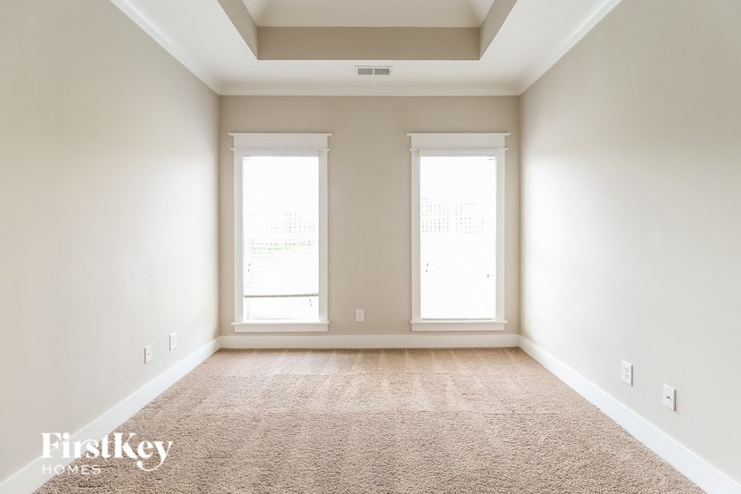 a empty room with two windows and a carpet