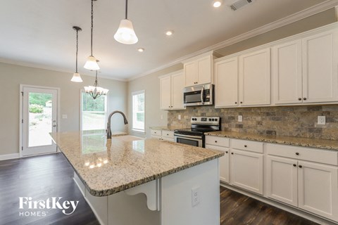 a kitchen with white cabinets and a granite counter top