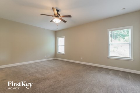 a living room with carpet and a ceiling fan