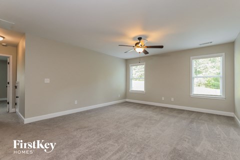 the master bedroom has a carpeted floor and a ceiling fan