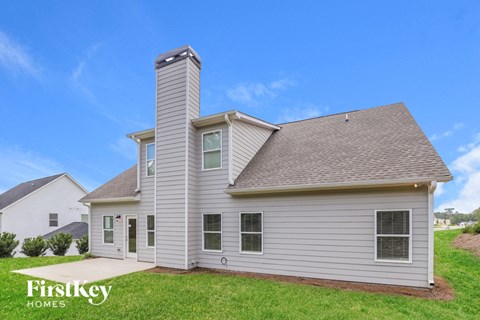 side view of home with white siding and green grass and a blue sky