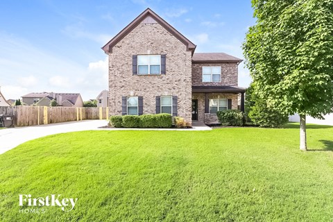 a large lawn in front of a brick house