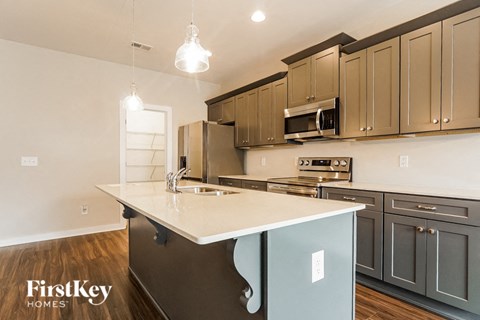 a kitchen with gray cabinets and a white counter top