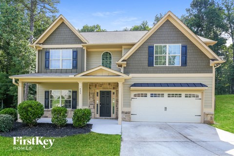 a beige house with a driveway and a garage door