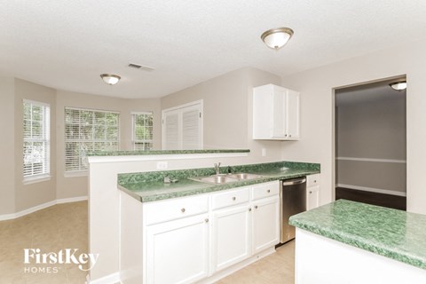 A kitchen with granite countertops and white cabinets.