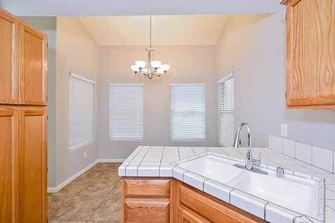 A kitchen with wooden cabinets and a white sink.