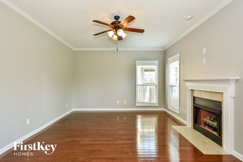 A room with a fireplace and a ceiling fan.