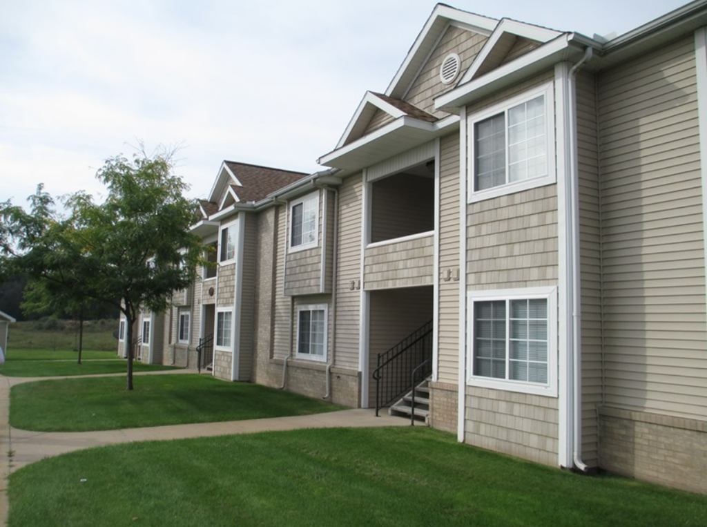 a row of townhomes with grass and trees in front of them