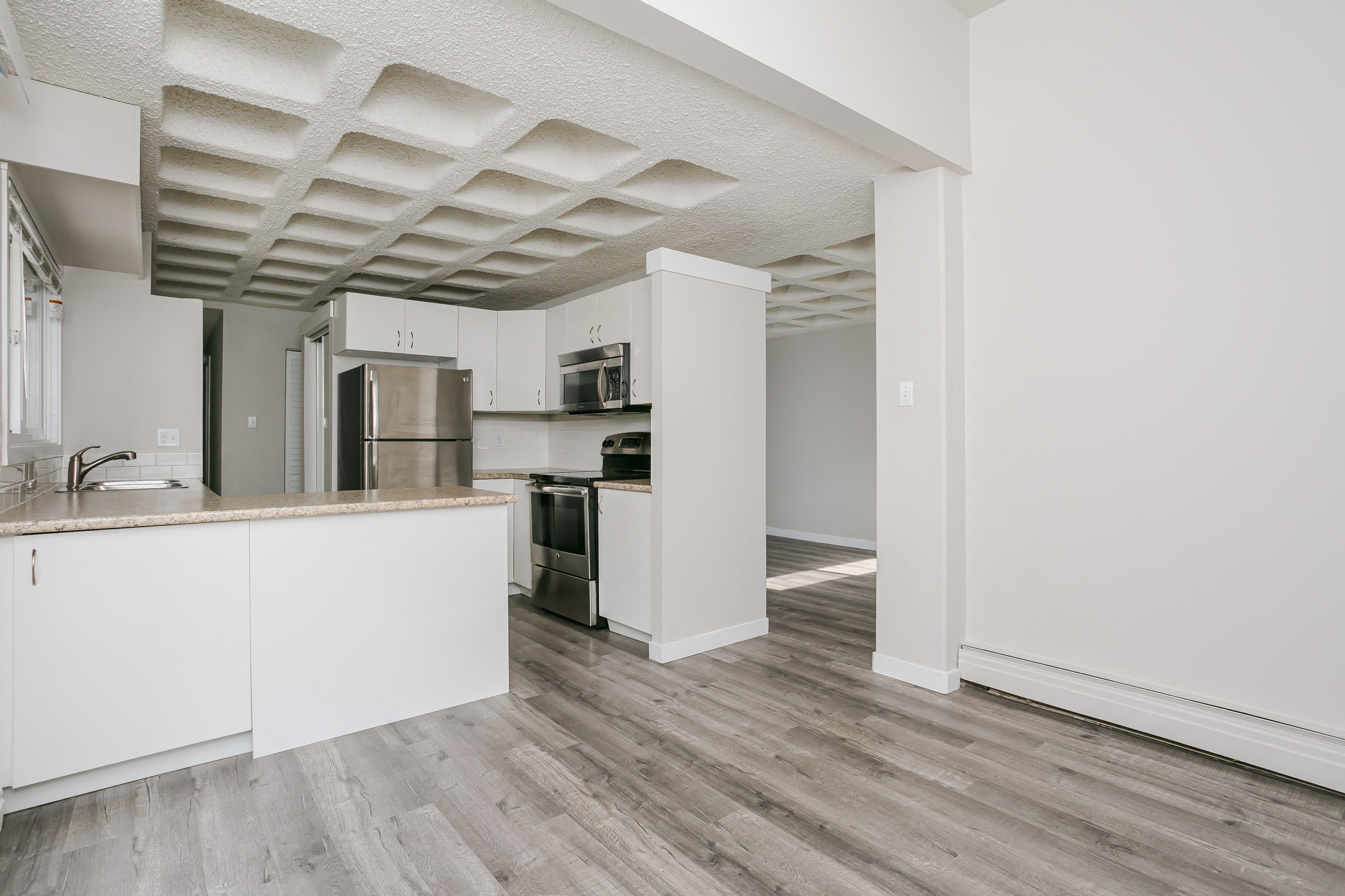 a kitchen with white cabinets and a stainless steel refrigerator