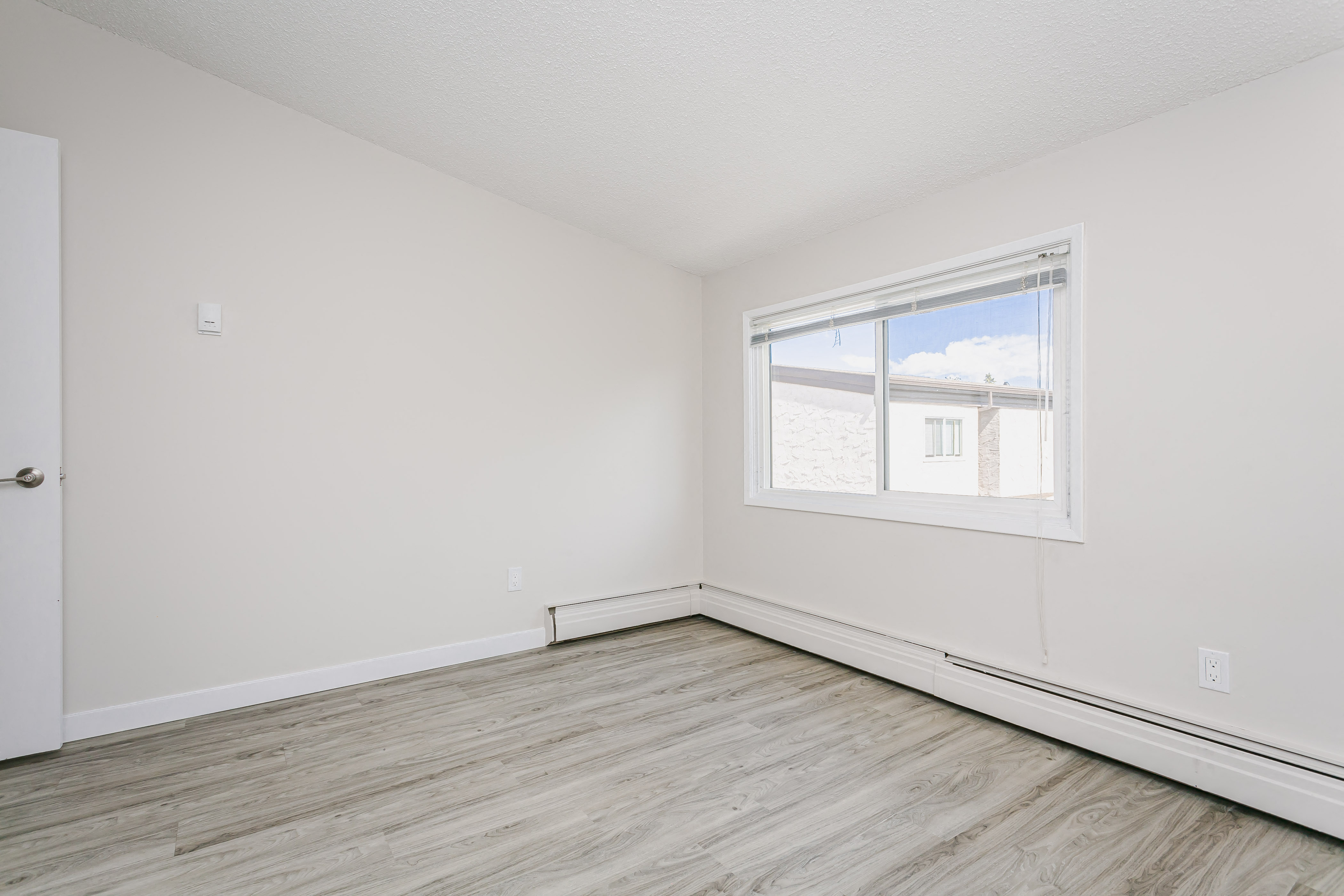 an empty room with white walls and a window