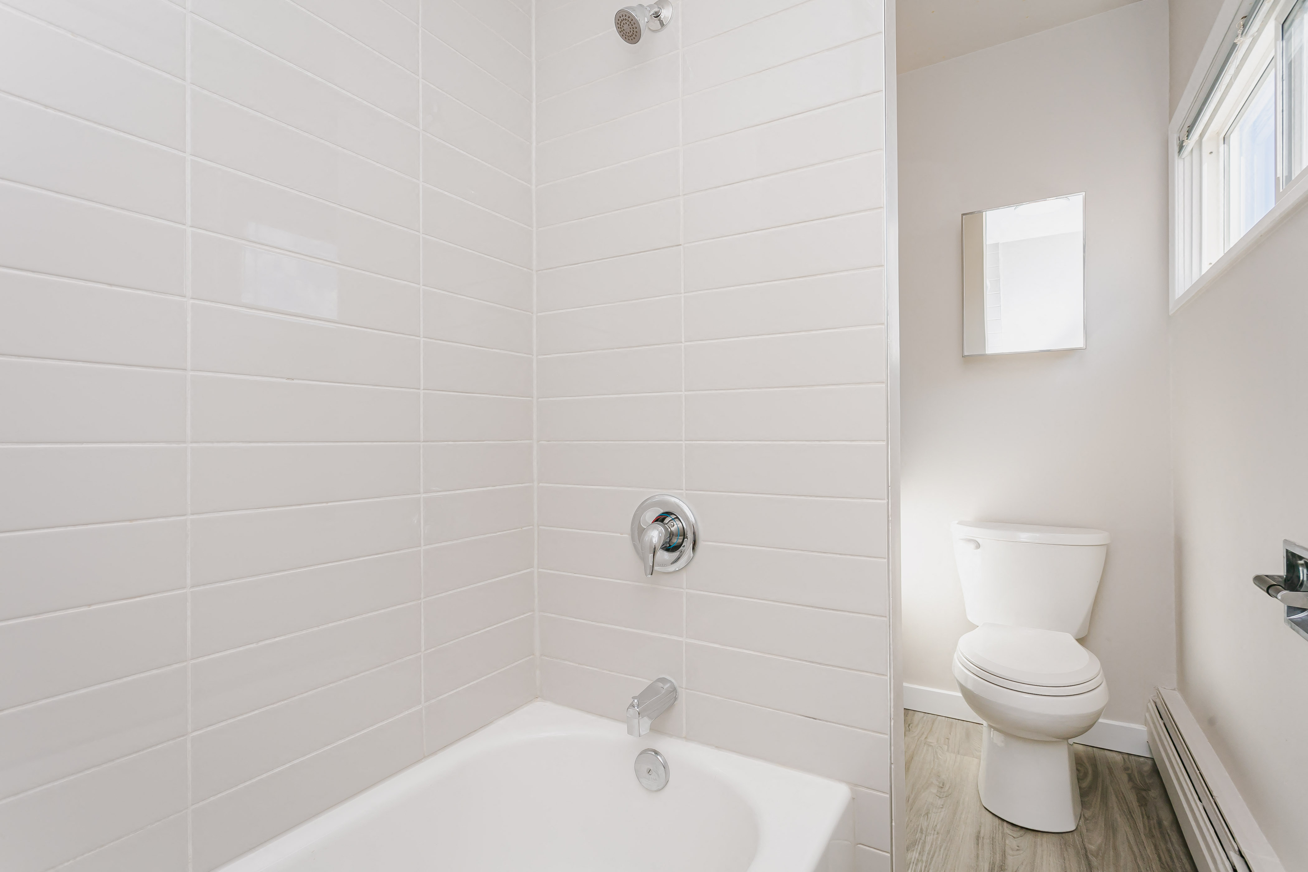 a white bathroom with a toilet and a tub