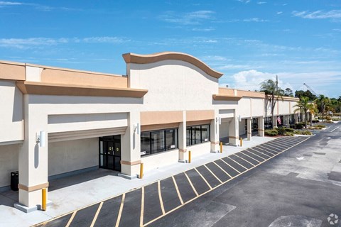 the exterior of a shopping center with empty parking spaces