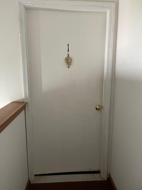 a white door with a door knob and a white wall
