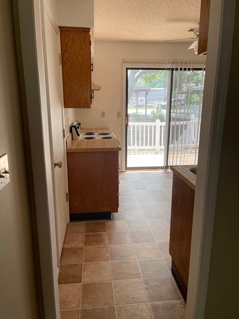 an empty kitchen with a door to a balcony
