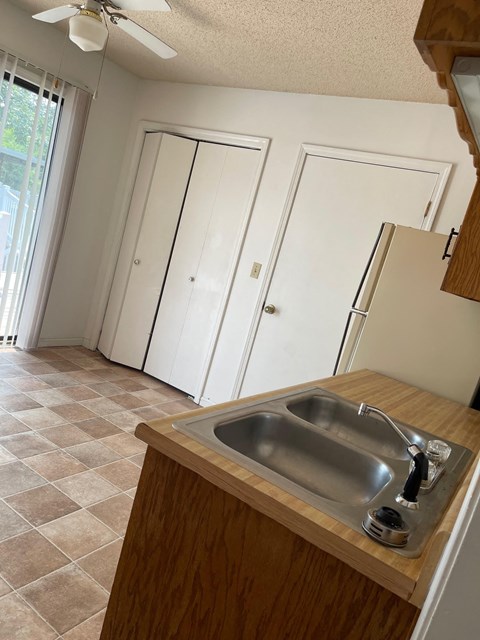 an empty kitchen with a sink and a refrigerator