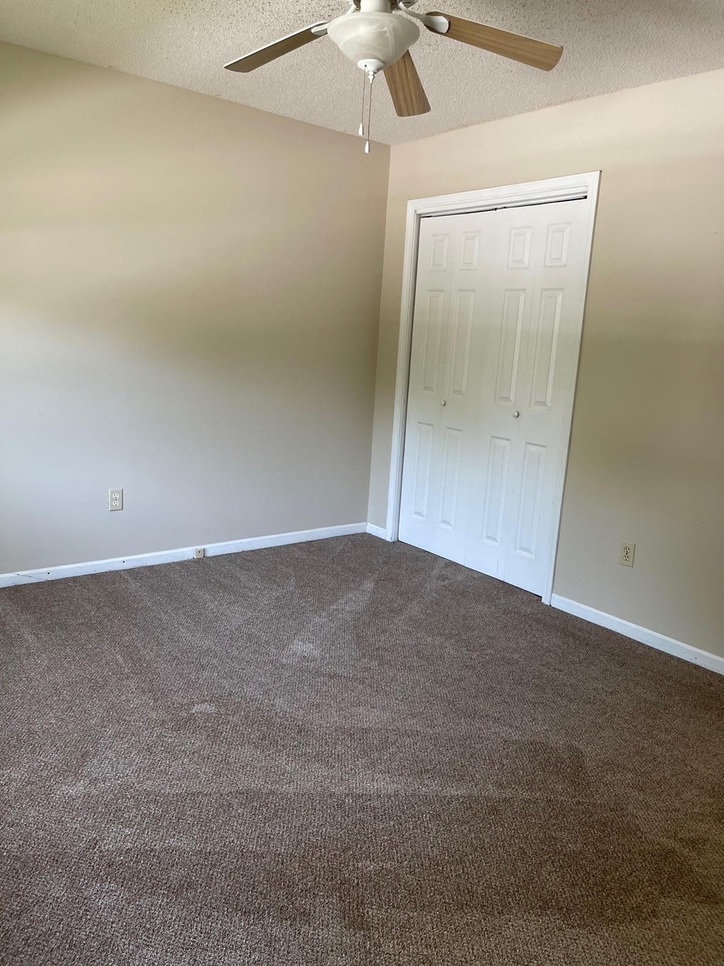 a room with a carpeted floor and a ceiling fan