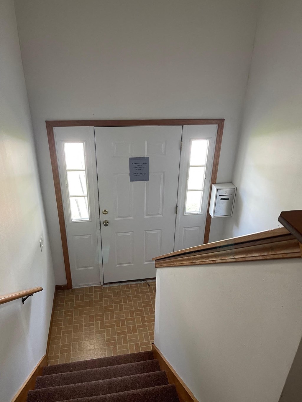 a stairway with a white door and a sign on the door