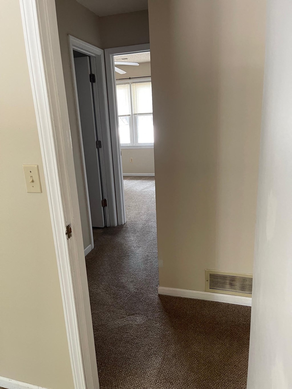 a room with a carpeted floor and a doorway into a room