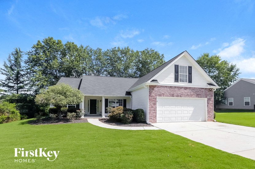 A house with a garage and a driveway in front of it.