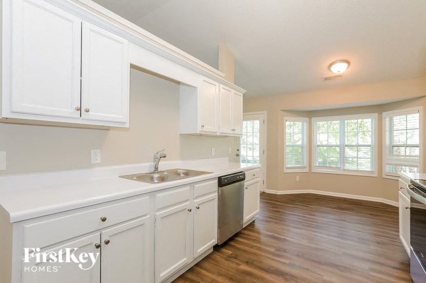 A kitchen with white cabinets and a sink.