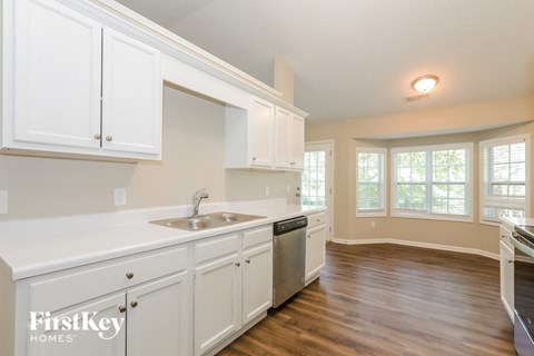 A kitchen with white cabinets and a sink.