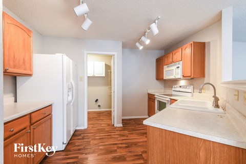 A kitchen with wooden cabinets and a white counter top.