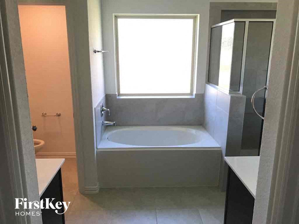 a small bathroom with a tub and a window