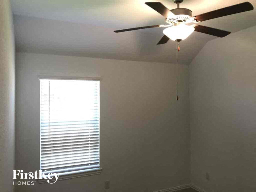 a bedroom with a ceiling fan and a window